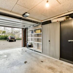 Close-up of a modern belt-drive garage door opener motor mounted to the ceiling, highlighting the hardware that can produce odd sounds or burning smells when failing.