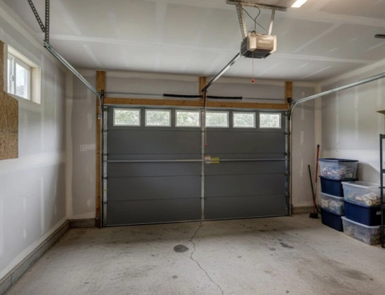 Interior view of a gray double-car garage door installation featuring a ceiling-mounted chain-drive opener and heavy-duty tracks by Greer Garage Doors.